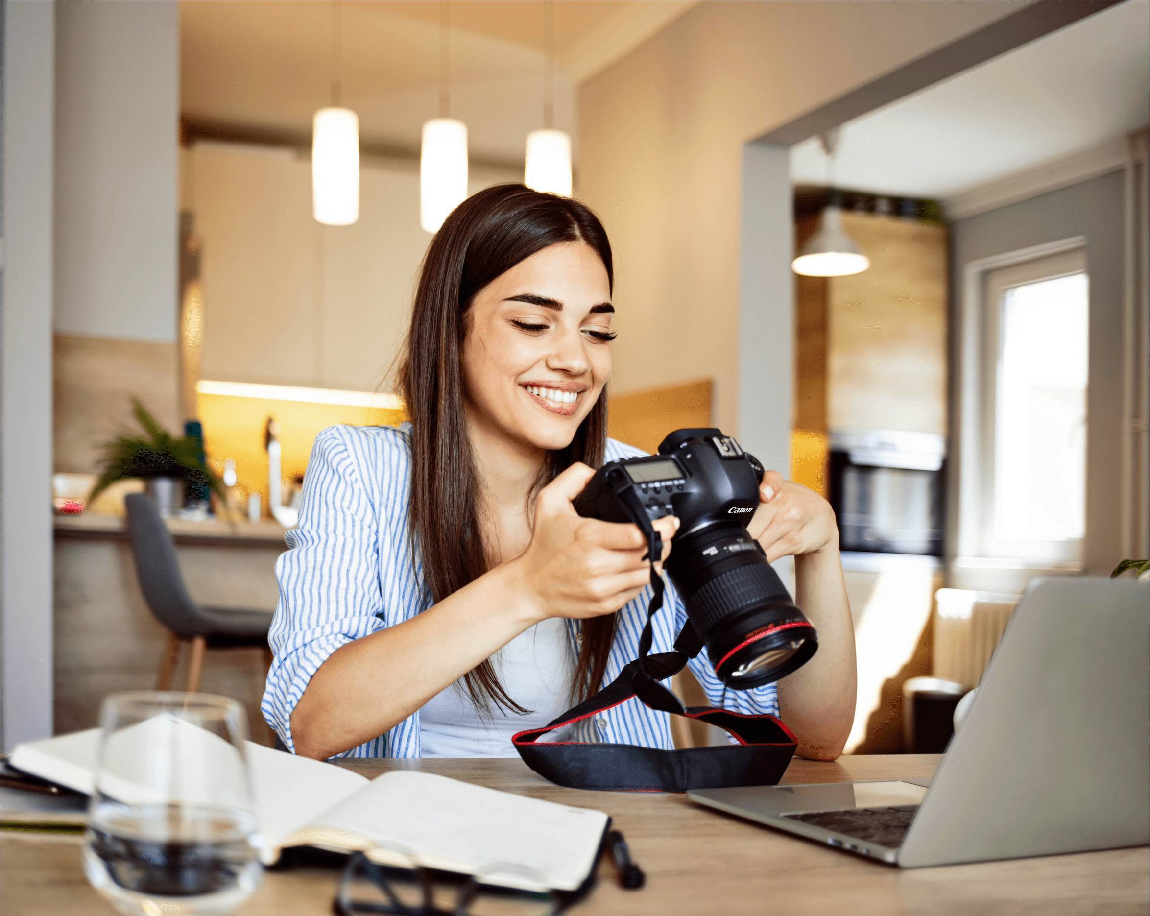 Mujer sonriente sosteniendo una cámara Canon en un taller de fotografía